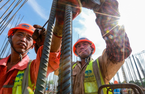 濉溪县棚户区改造项目工地上 , 烈日下工作的钢筋工人.